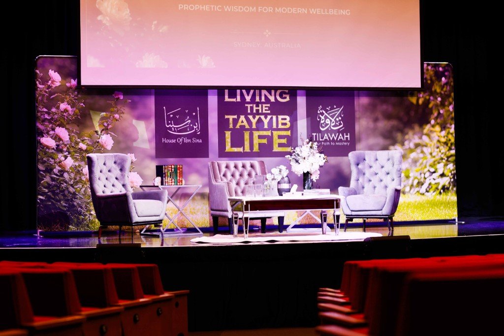 Elegant stage set for Living the Tayyib Life with seating and floral backdrop